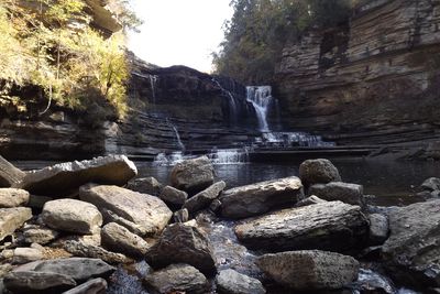 Cummins Falls and its pool viewed across large boulders in the gorge.
