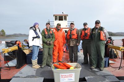 Eagle Watch crew members and safety gear on the open boat deck.