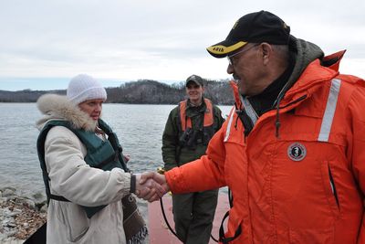 An Eagle Watch crew member greeting a passenger beside Dale Hollow Lake.