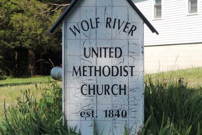 Wolf River United Methodist Church sign beside the church.