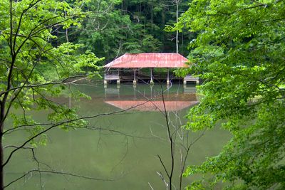 The boathouse along Standing Stone Lake, viewed from a wooded trail.